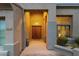 Inviting front entrance with a rustic wood door, stone walkway, and warm lighting creating a welcoming ambiance at 11036 E Evans Rd, Scottsdale, AZ 85255