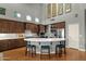 Open kitchen featuring stainless steel appliances, hardwood floors, kitchen island with seating and marble countertops at 11036 E Evans Rd, Scottsdale, AZ 85255