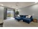 Stylish living room with a comfortable blue sectional, access to balcony and great natural light at 11036 E Evans Rd, Scottsdale, AZ 85255