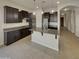 Well-lit kitchen featuring dark wood cabinets, stainless steel appliances, and an island with a sink at 12164 S 184Th Ave, Goodyear, AZ 85338
