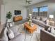 Cozy living room featuring plush seating, stylish rug, and abundant natural light from the large windows at 12164 S 184Th Ave, Goodyear, AZ 85338
