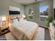 Bright main bedroom showcases a wooden bed frame, a large artwork, and dual windows at 12164 S 184Th Ave, Goodyear, AZ 85338