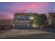 Beautiful two-story home featuring a two-car garage and attractive landscaping at dusk at 14532 N 146Th Ln, Surprise, AZ 85379