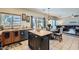 Bright kitchen with tiled floor, wood cabinets, central island, and seamless flow to the living room at 14532 N 146Th Ln, Surprise, AZ 85379