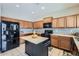 Bright kitchen featuring an island, plenty of cabinet space, modern appliances, and tile flooring at 14532 N 146Th Ln, Surprise, AZ 85379