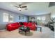 Comfortable living area featuring a red sectional sofa, neutral carpeting, and ample natural light at 14532 N 146Th Ln, Surprise, AZ 85379