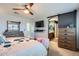 Open main bedroom with a ceiling fan, TV, modern furniture, and an en-suite bathroom at 14532 N 146Th Ln, Surprise, AZ 85379
