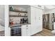 Stylish bar area with a wine refrigerator, floating shelves, and a coffee station at 1901 W Mulberry Dr, Chandler, AZ 85286