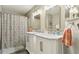 Updated bathroom featuring double sinks, marble countertops, modern fixtures, and decorative shower curtain at 1901 W Mulberry Dr, Chandler, AZ 85286