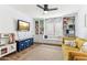 Bright bedroom features built-in shelving, a window seat, a television, and a comfortable yellow sofa at 1901 W Mulberry Dr, Chandler, AZ 85286