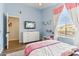 Bright bedroom with cool blue walls, wood flooring, window, and white dresser with television at 1901 W Mulberry Dr, Chandler, AZ 85286