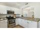 Modern kitchen featuring stainless steel appliances, white cabinets, and granite countertops at 20218 N 33Rd Pl, Phoenix, AZ 85050