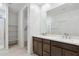 Dual-sink vanity with modern fixtures, bright lighting, and storage, enhancing the functionality and aesthetics of the bathroom at 25606 N 154Th Ln, Surprise, AZ 85387