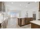 Open-concept kitchen boasts an island, stainless steel appliances, and tile flooring, flowing to the living area at 25606 N 154Th Ln, Surprise, AZ 85387
