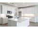 Bright kitchen features a large island, stainless steel appliances, and white cabinets at 25606 N 154Th Ln, Surprise, AZ 85387