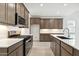 Stylish kitchen with stainless steel appliances, a gas range, custom cabinets, and a large island at 25606 N 154Th Ln, Surprise, AZ 85387