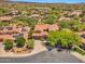 Expansive aerial view of a residential neighborhood featuring homes with tile roofs, solar panels, and mature trees at 30227 N 124Th Dr, Peoria, AZ 85383