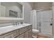 Bathroom featuring a vanity with a quartz countertop, modern fixtures, and a walk-in shower with glass doors at 30227 N 124Th Dr, Peoria, AZ 85383