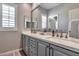 Elegant bathroom featuring double sinks, a large mirror, shaker cabinets, and modern faucets, creating a luxurious feel at 30227 N 124Th Dr, Peoria, AZ 85383