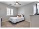 Comfortable bedroom with a ceiling fan, plush carpet, and natural light streaming through the window with white shutters at 30227 N 124Th Dr, Peoria, AZ 85383