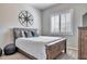 Cozy bedroom with a rustic wood bed, metal art, and window with shutters at 30227 N 124Th Dr, Peoria, AZ 85383