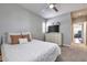 Bright bedroom featuring a cozy bed, dresser with TV, and a view through the window, creating a serene and inviting space at 30227 N 124Th Dr, Peoria, AZ 85383