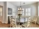 Well-lit dining room with a rustic round table, stylish chairs, and modern light fixture at 30227 N 124Th Dr, Peoria, AZ 85383
