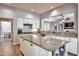 Bright kitchen with granite countertops, white cabinetry, and an open layout leading to the living area at 30227 N 124Th Dr, Peoria, AZ 85383