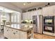 Bright open kitchen with white cabinets, granite countertops, stainless steel appliances, and a center island at 30227 N 124Th Dr, Peoria, AZ 85383