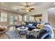 Spacious living room with a large sectional sofa, ceiling fan, and view of the backyard at 30227 N 124Th Dr, Peoria, AZ 85383