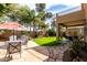 Lush backyard oasis with green grass, palm trees, and a cozy patio area at 32795 N Hidden Canyon Dr, San Tan Valley, AZ 85144