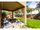 Covered patio with outdoor seating area, lush green lawn, and mature landscaping at 32795 N Hidden Canyon Dr, San Tan Valley, AZ 85144