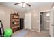 Neutral carpeted bedroom featuring ceiling fan, bookshelf, black safe, and workout accessories at 32795 N Hidden Canyon Dr, San Tan Valley, AZ 85144
