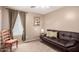 Comfortable living room featuring a leather sofa, chair, neutral color scheme, and natural light from a window at 32795 N Hidden Canyon Dr, San Tan Valley, AZ 85144