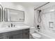 Stylish bathroom with gray vanity, white countertop, and tub with tiled surround at 4220 E Everett Dr, Phoenix, AZ 85032