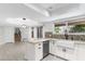 Bright, modern kitchen featuring a breakfast bar, white cabinetry, stainless steel appliances, and a farmhouse sink at 4220 E Everett Dr, Phoenix, AZ 85032