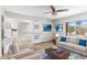 Cozy staged living room with an open doorway to the kitchen, neutral furniture, and access to outdoor views at 4220 E Everett Dr, Phoenix, AZ 85032