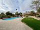 Sparkling pool surrounded by a paver patio, green grass and desert landscaping; great for outdoor entertaining at 4220 E Everett Dr, Phoenix, AZ 85032