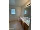 Bright bathroom with a tiled floor, window, toilet and a vanity with a sink and mirror at 4943 W Lynne Ln, Laveen, AZ 85339