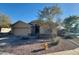 Charming single-story home showcasing desert landscaping, a two-car garage, and light tan stucco at 4943 W Lynne Ln, Laveen, AZ 85339