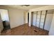 Bedroom with wood floors, closet organizer, and an open doorway to another room at 508 S 98Th St, Mesa, AZ 85208