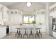 Bright, modern kitchen boasts white cabinets, a spacious island with seating, and sleek stainless steel appliances at 520 E Aurora Dr, San Tan Valley, AZ 85140
