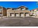 View of the condo's exterior featuring three units, each with an attached garage and neutral toned stucco at 525 N Miller Rd # 113, Scottsdale, AZ 85257