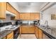 Well-lit kitchen with stainless steel appliances, granite counters and light wood cabinetry at 525 N Miller Rd # 113, Scottsdale, AZ 85257