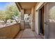 A neutral toned condo patio with a view of neighborhood trees, concrete tiling, and a sliding glass door at 525 N Miller Rd # 113, Scottsdale, AZ 85257