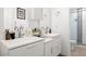 Modern bathroom with double sinks, sleek white vanities, and glass-enclosed shower with decorative tile accent at 6845 E Lewis Ave, Scottsdale, AZ 85257