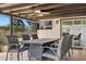 Covered patio with comfortable seating, dining table, and outdoor TV, offering a relaxing outdoor experience at 6845 E Lewis Ave, Scottsdale, AZ 85257