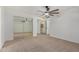 Carpeted bedroom with a ceiling fan and mirrored closet doors leading to an ensuite bathroom at 8201 W Tuckey Ln, Glendale, AZ 85303