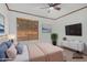 Comfortable bedroom with soft lighting, plush carpet, a large window and flat screen television at 8201 W Tuckey Ln, Glendale, AZ 85303