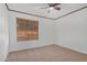 Inviting bedroom with plush carpeting, ceiling fan, and natural light from the window at 8201 W Tuckey Ln, Glendale, AZ 85303